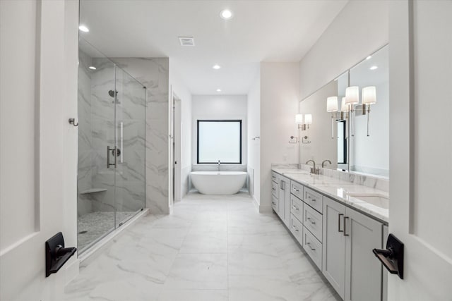 full bath featuring a freestanding tub, a sink, marble finish floor, a marble finish shower, and double vanity