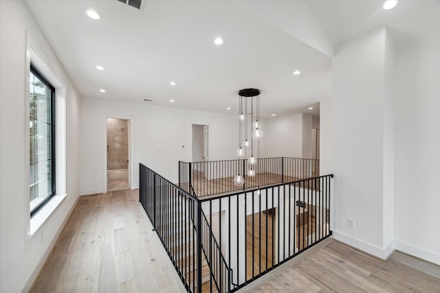 corridor with an upstairs landing, recessed lighting, baseboards, and wood finished floors