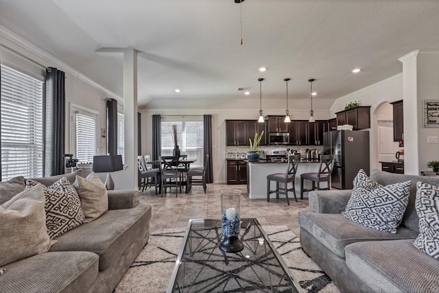 living area featuring light tile patterned floors, arched walkways, crown molding, and recessed lighting