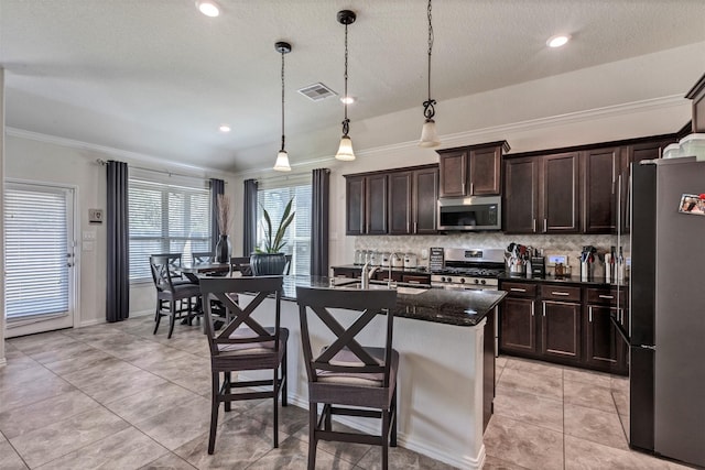 kitchen with visible vents, appliances with stainless steel finishes, a kitchen breakfast bar, ornamental molding, and backsplash