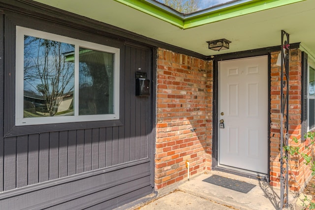 view of exterior entry with brick siding