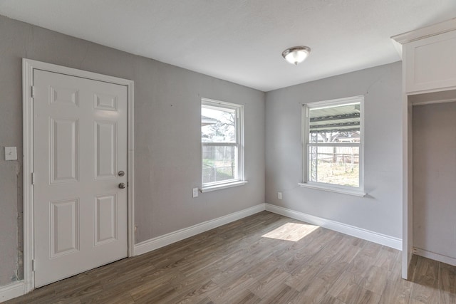 empty room with light wood-type flooring and baseboards