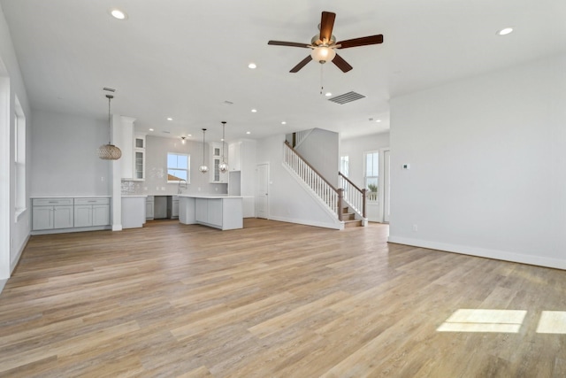 26726 Estuary Dr, Galveston, TX 77554 - unfurnished living room featuring light wood finished floors, recessed lighting, visible vents, stairway, and baseboards