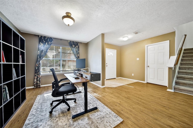 office featuring wood finished floors, visible vents, and baseboards