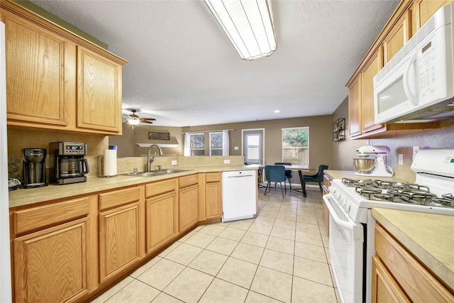 kitchen with white appliances, light countertops, a sink, and light tile patterned floors