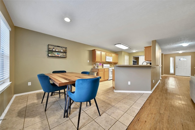 dining room featuring baseboards and light tile patterned floors