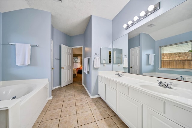 bathroom with a sink, tile patterned flooring, connected bathroom, and lofted ceiling