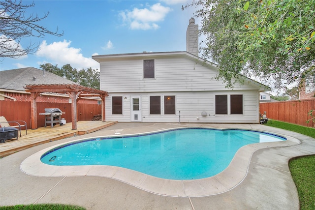 view of swimming pool with a deck, a fenced backyard, a fenced in pool, and a pergola