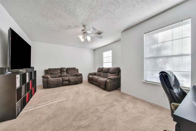 office featuring light colored carpet, visible vents, ceiling fan, and a textured ceiling