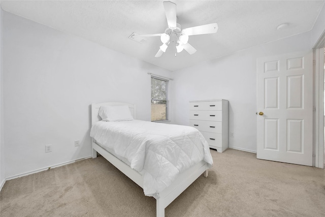 bedroom with ceiling fan, a textured ceiling, and light colored carpet