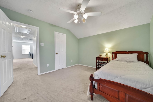 bedroom with attic access, baseboards, vaulted ceiling, and light colored carpet