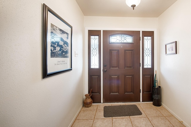 tiled entryway featuring baseboards