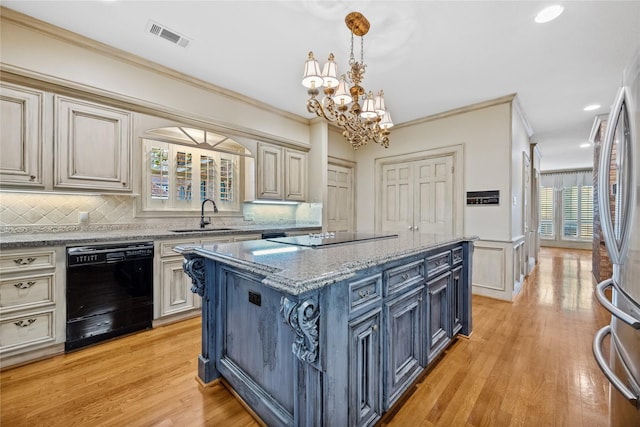 kitchen with black appliances, visible vents, ornamental molding, and a sink