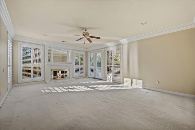 unfurnished living room with baseboards, ornamental molding, carpet flooring, and a glass covered fireplace