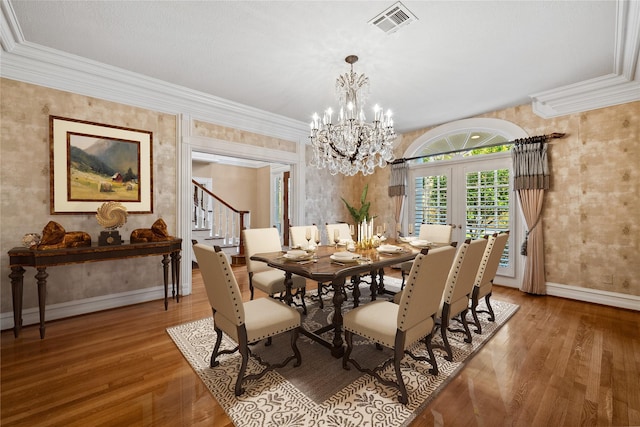 dining area with ornamental molding, wood finished floors, visible vents, and baseboards