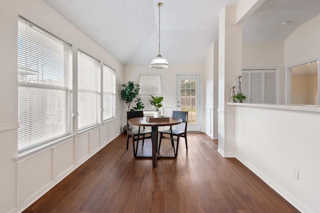 dining space featuring vaulted ceiling, dark wood-style flooring, and a wealth of natural light