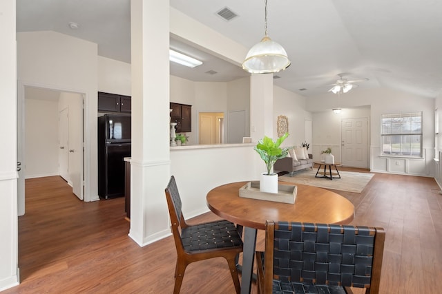 dining area with dark wood-style flooring, visible vents, vaulted ceiling, and ceiling fan