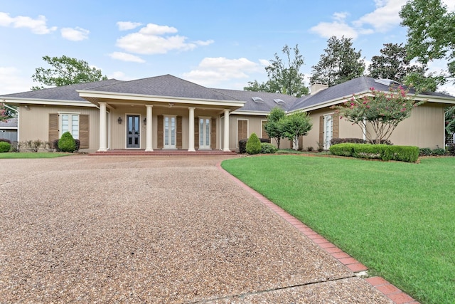 view of front of property featuring french doors, a front lawn, and a chimney