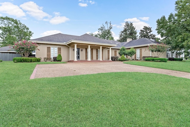 ranch-style home featuring a front yard, driveway, and a chimney