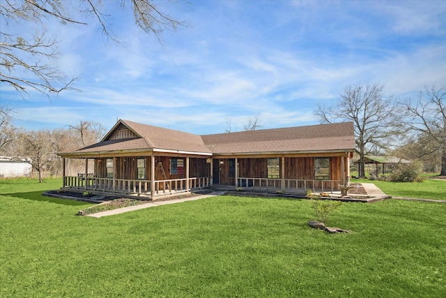 rear view of house with roof with shingles and a yard