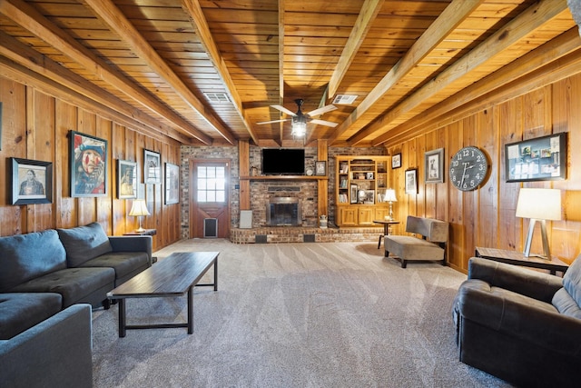 living room featuring beam ceiling, a fireplace, visible vents, carpet flooring, and wooden walls