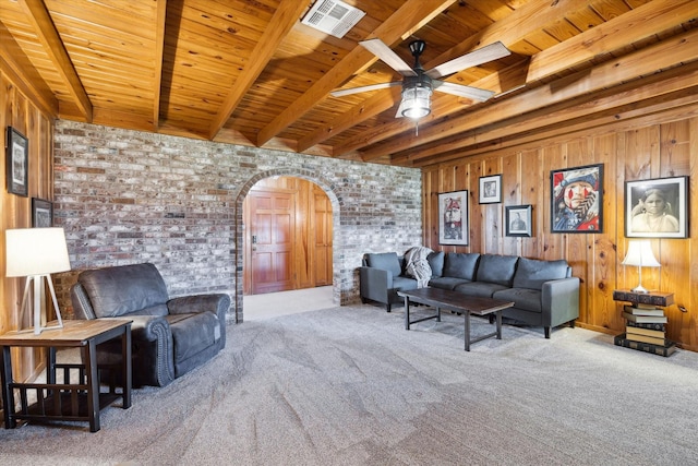 living room with arched walkways, visible vents, wood ceiling, brick wall, and beamed ceiling