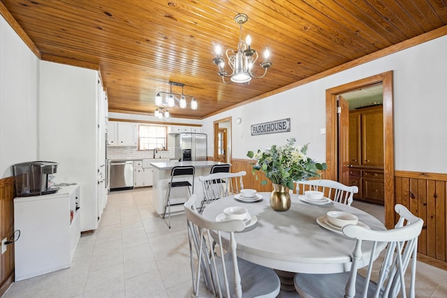 dining space featuring wooden ceiling, light tile patterned floors, a notable chandelier, and wainscoting