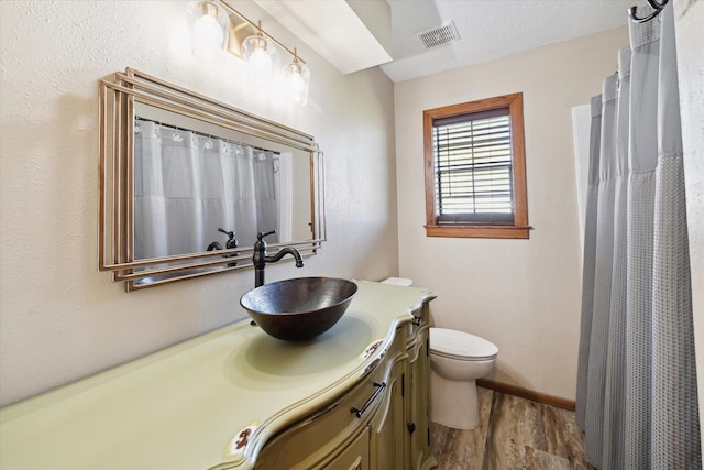 full bathroom featuring baseboards, visible vents, toilet, wood finished floors, and vanity