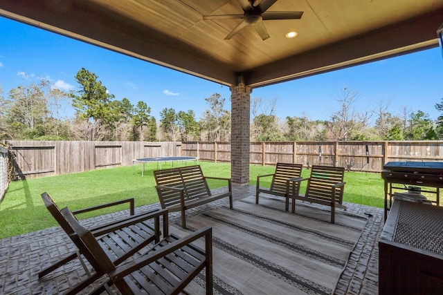 view of patio / terrace with a fenced backyard, a trampoline, and a ceiling fan