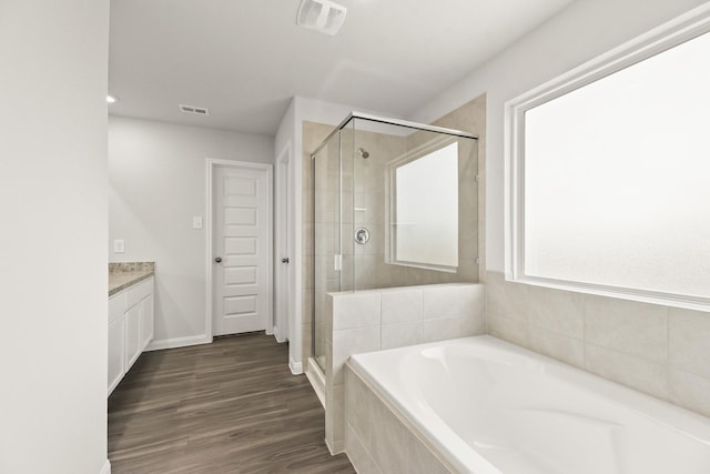 16535 Willow Forest Dr, Conroe, TX 77302 - full bathroom featuring a garden tub, a shower stall, vanity, wood finished floors, and baseboards