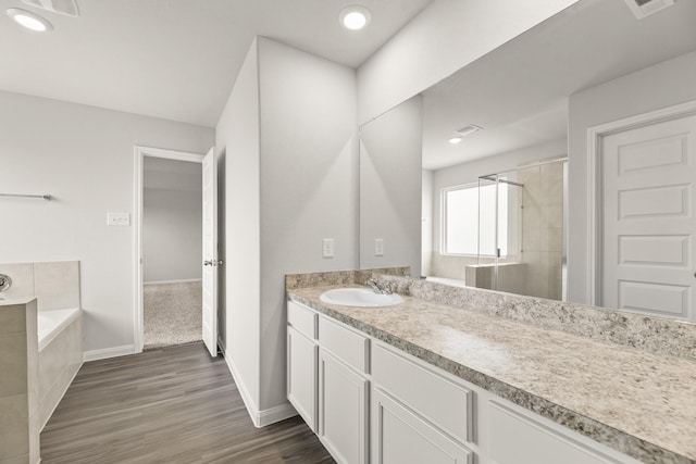 16535 Willow Forest Dr, Conroe, TX 77302 - full bathroom featuring vanity, a bath, wood finished floors, tiled shower, and baseboards
