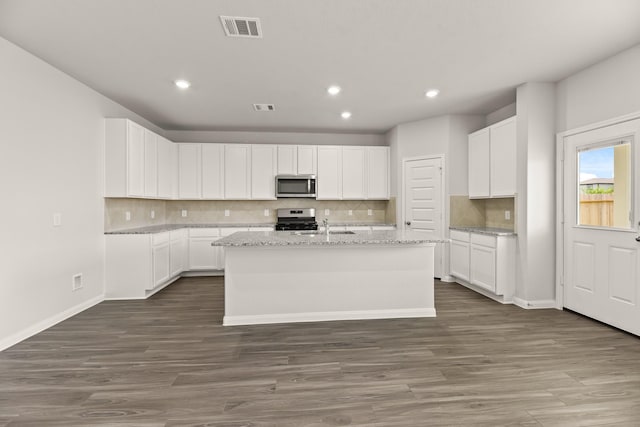 16535 Willow Forest Dr, Conroe, TX 77302 - kitchen with stainless steel microwave, range with gas cooktop, decorative backsplash, recessed lighting, and dark wood-type flooring