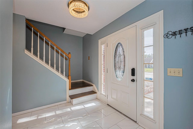 foyer entrance with tile patterned floors and stairway