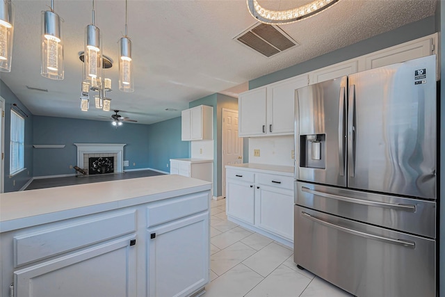 kitchen featuring visible vents, light countertops, stainless steel fridge with ice dispenser, and white cabinetry