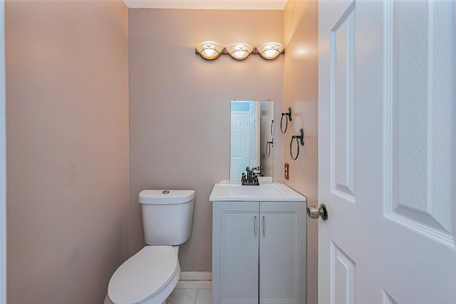 half bath with tile patterned flooring, toilet, vanity, and baseboards