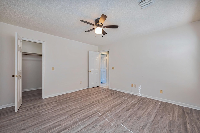 unfurnished bedroom featuring wood finished floors, visible vents, and baseboards