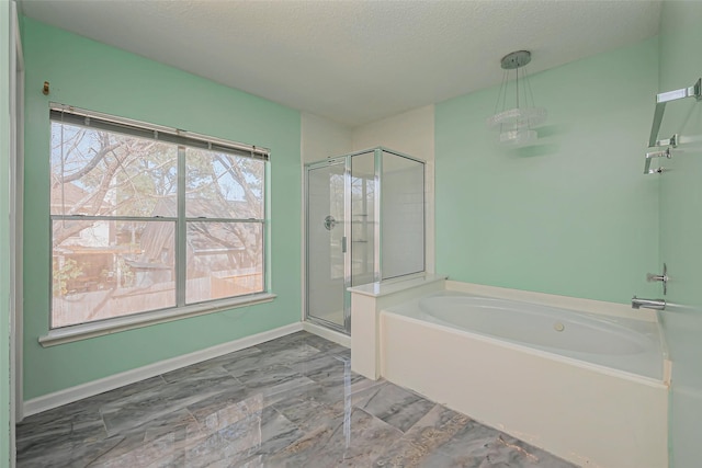 full bath with baseboards, a stall shower, a textured ceiling, and a garden tub