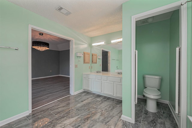 bathroom with visible vents, toilet, baseboards, and double vanity