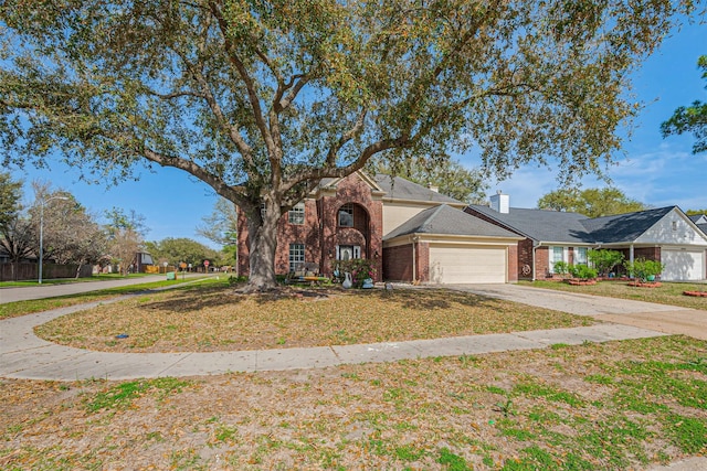 view of front of home with brick siding, concrete driveway, a garage, and a front yard