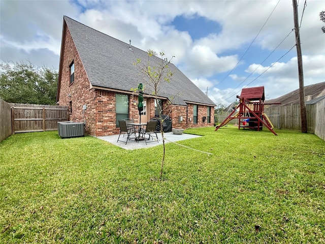 rear view of property featuring a patio area, a playground, brick siding, and a lawn