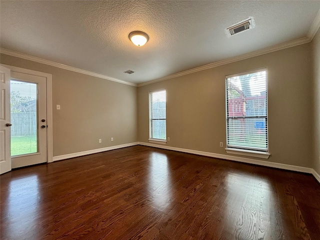 unfurnished room with dark wood-style floors, visible vents, and crown molding