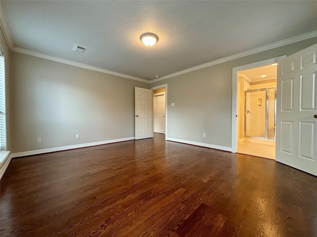 unfurnished room featuring dark wood-style floors, crown molding, visible vents, a textured ceiling, and baseboards