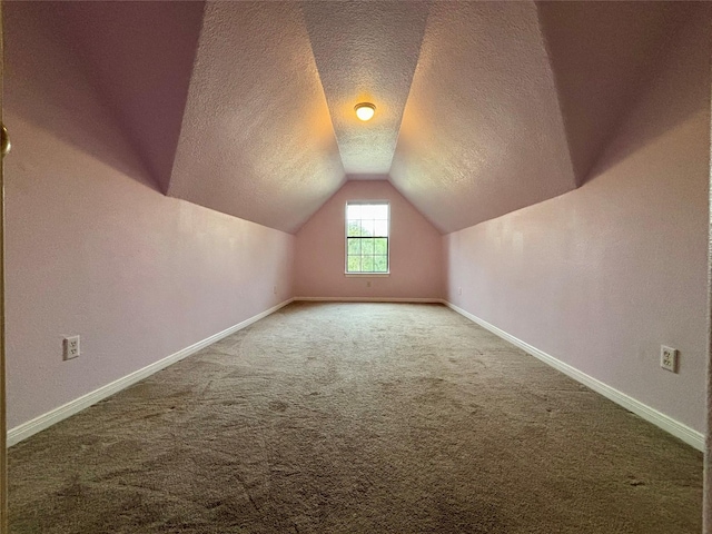 bonus room with carpet floors, baseboards, vaulted ceiling, and a textured ceiling