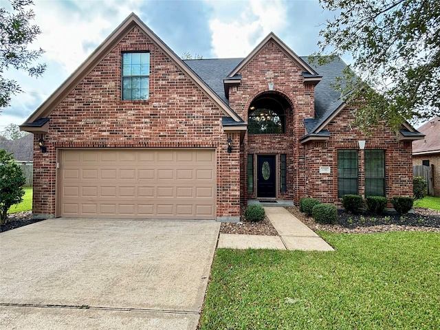 traditional-style house featuring brick siding, driveway, a front lawn, and roof with shingles