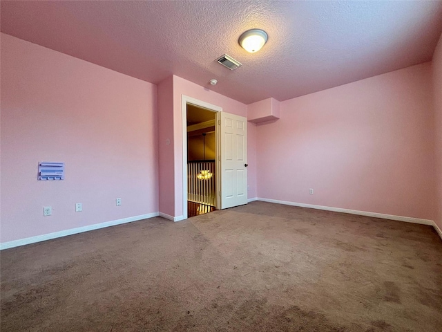 unfurnished bedroom with baseboards, carpet, visible vents, and a textured ceiling