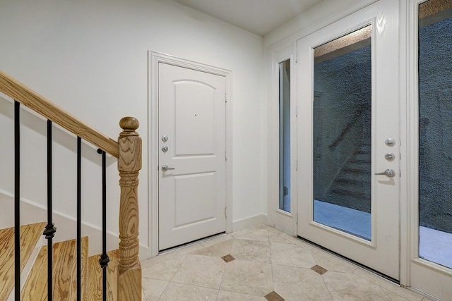 entryway featuring stairway, baseboards, and light tile patterned floors