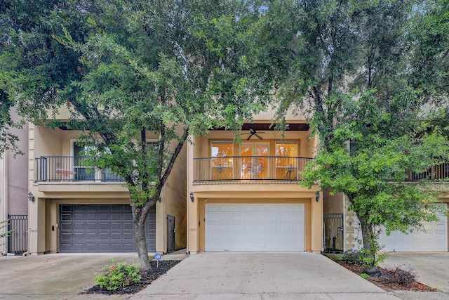 view of front of property featuring a garage, concrete driveway, a balcony, and stucco siding