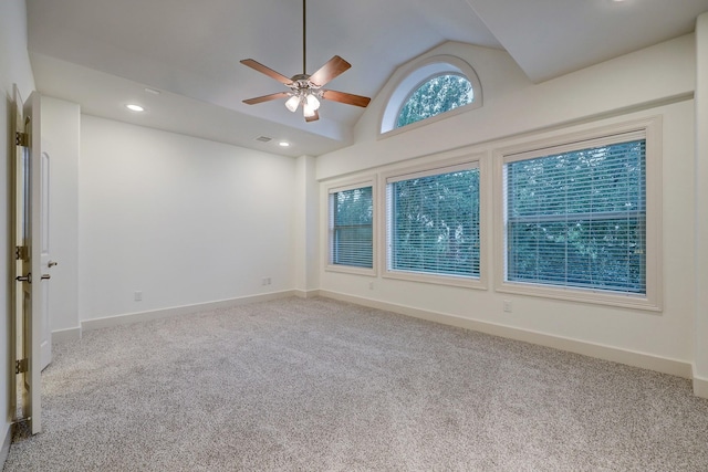 empty room with recessed lighting, light colored carpet, vaulted ceiling, and baseboards