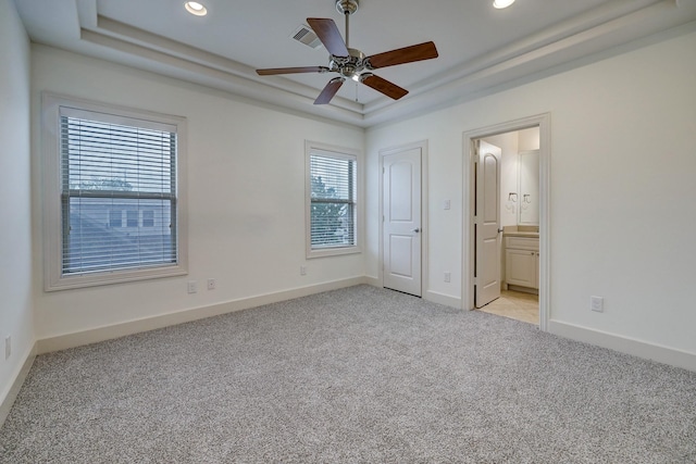 unfurnished bedroom featuring a tray ceiling, light carpet, baseboards, and recessed lighting