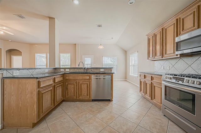 kitchen featuring appliances with stainless steel finishes, dark countertops, visible vents, and a sink